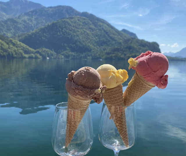 Ein köstliches Eis vor sagenhaftem Ausblick Ein Schokolade, Vanille und Himbeeren Eis im Glas, vor dem herrlichen Mondsee